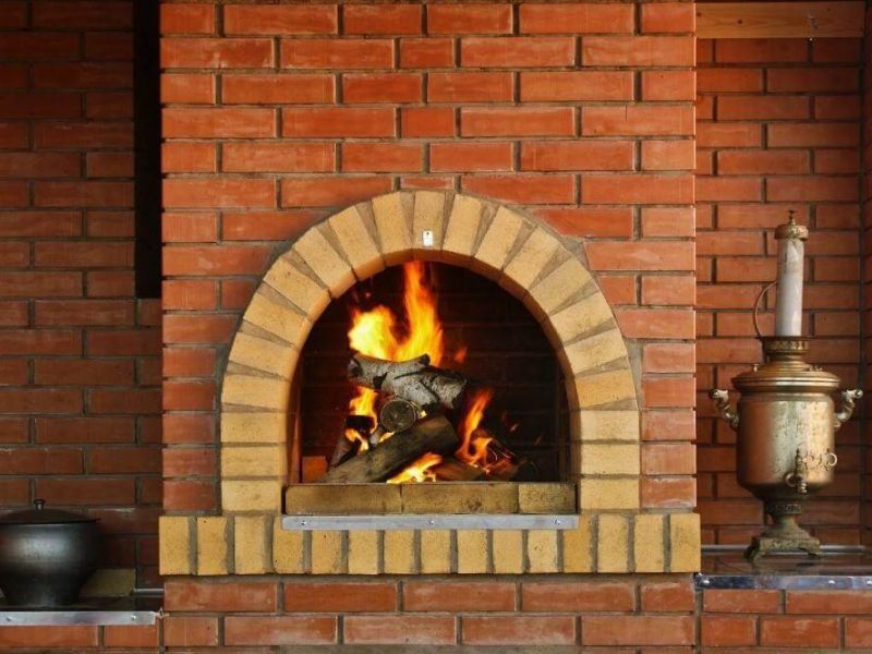 A roaring fire glowing within a brick fireplace