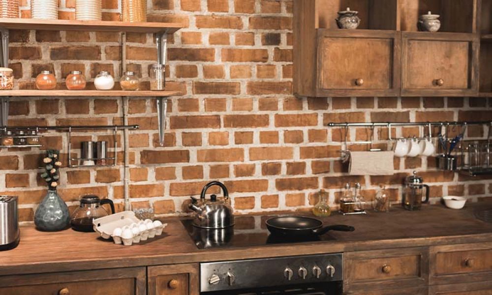 Rustic kitchen with brick backsplash, wooden cabinets, and modern appliances on wooden countertops for a cozy feel.
