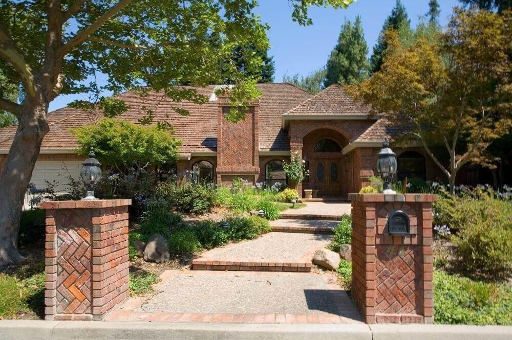 Large brick house and driveway, showcasing curb