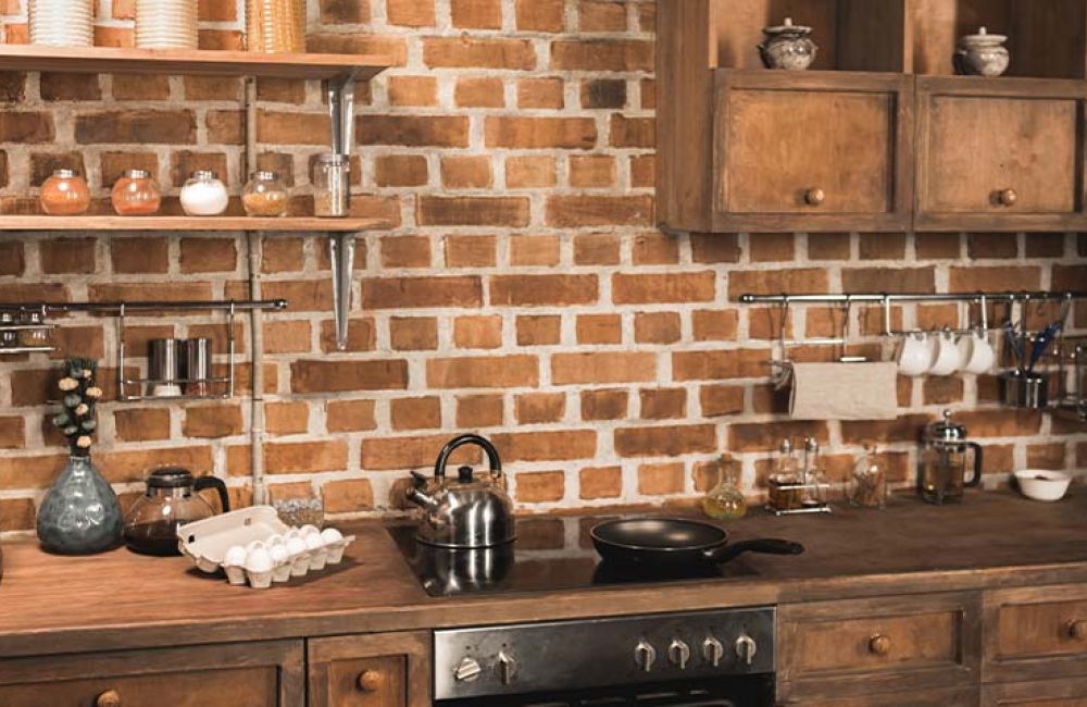 Rustic kitchen with brick backsplash, wooden cabinets, and modern appliances on wooden countertops for a cozy feel.