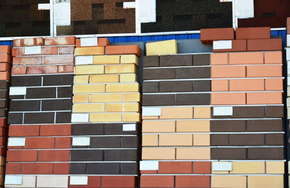 Various colored brick samples stacked for display at a building material store, showcasing diverse masonry options.