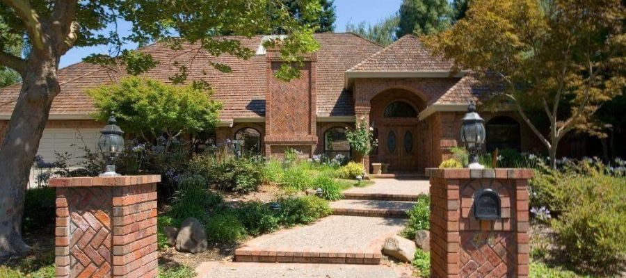 Large brick house and driveway, showcasing curb