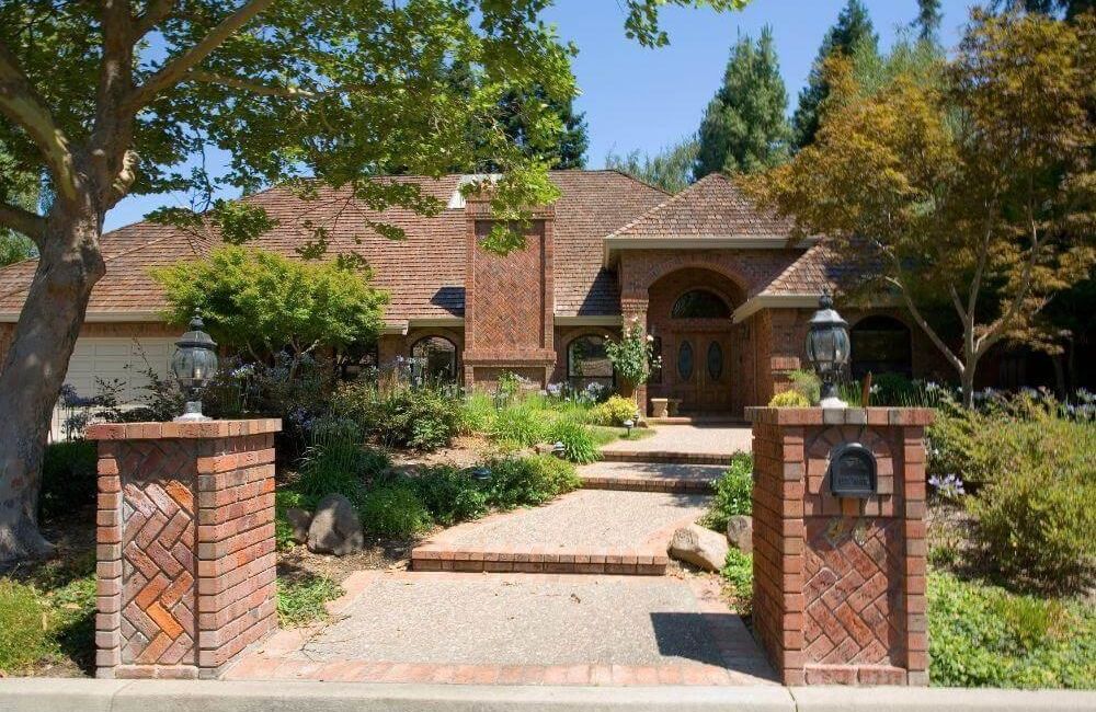 Large brick house and driveway, showcasing curb