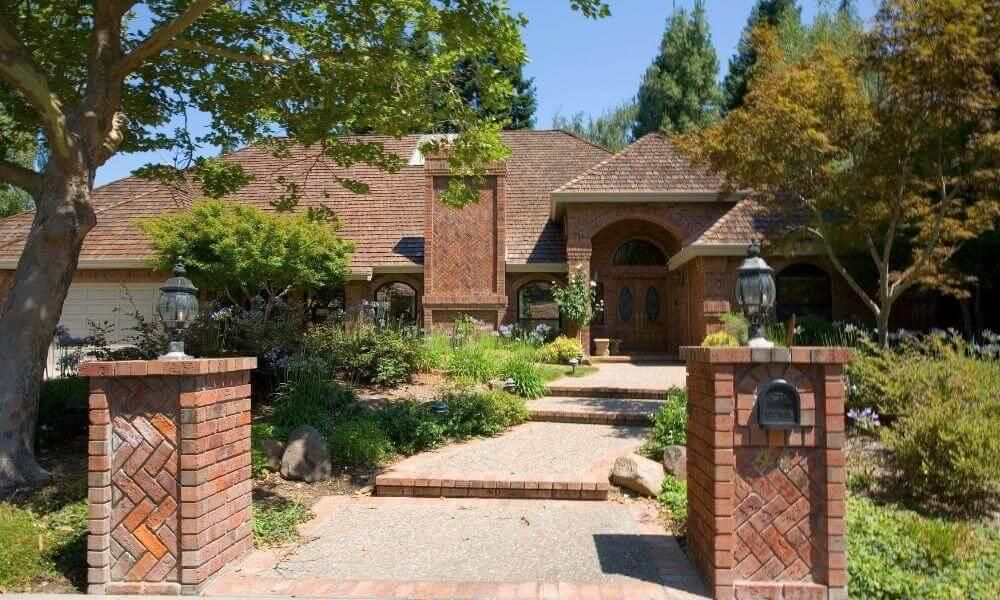 Large brick house and driveway, showcasing curb