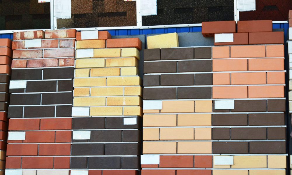 Various colored brick samples stacked for display at a building material store, showcasing diverse masonry options.