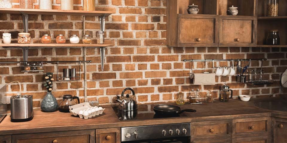Rustic kitchen with brick backsplash, wooden cabinets, and modern appliances on wooden countertops for a cozy feel.