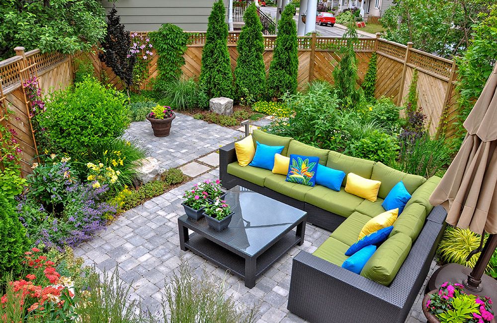 Colorful patio with cozy seating, lush garden plants, and vibrant flowers create a serene outdoor retreat.