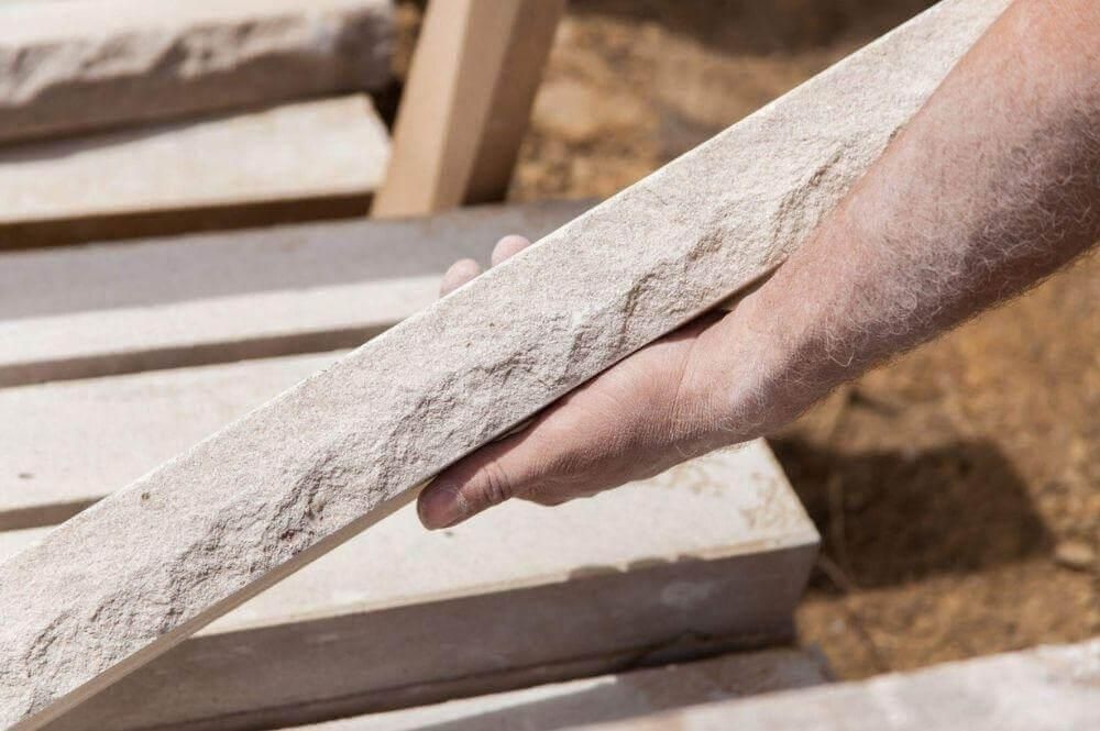 Person holding a stone block sample for veneers