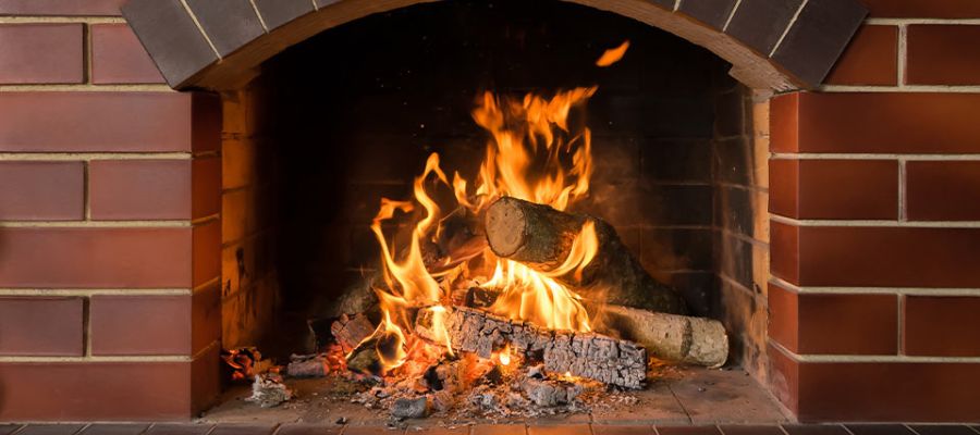 Cozy brick fireplace with burning logs, vibrant flames, and warm glow, perfect for winter ambiance and relaxation.