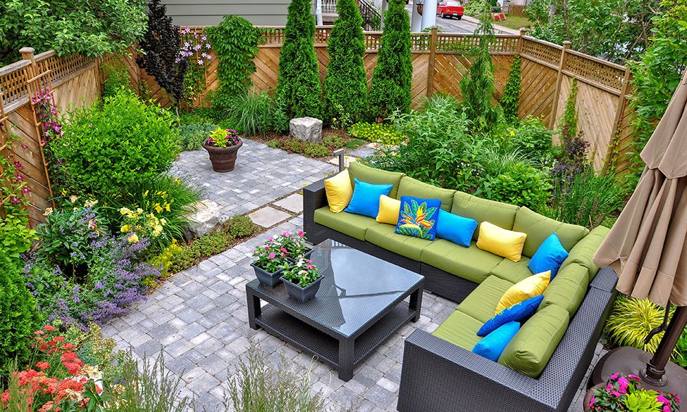 Colorful patio with cozy seating, lush garden plants, and vibrant flowers create a serene outdoor retreat.