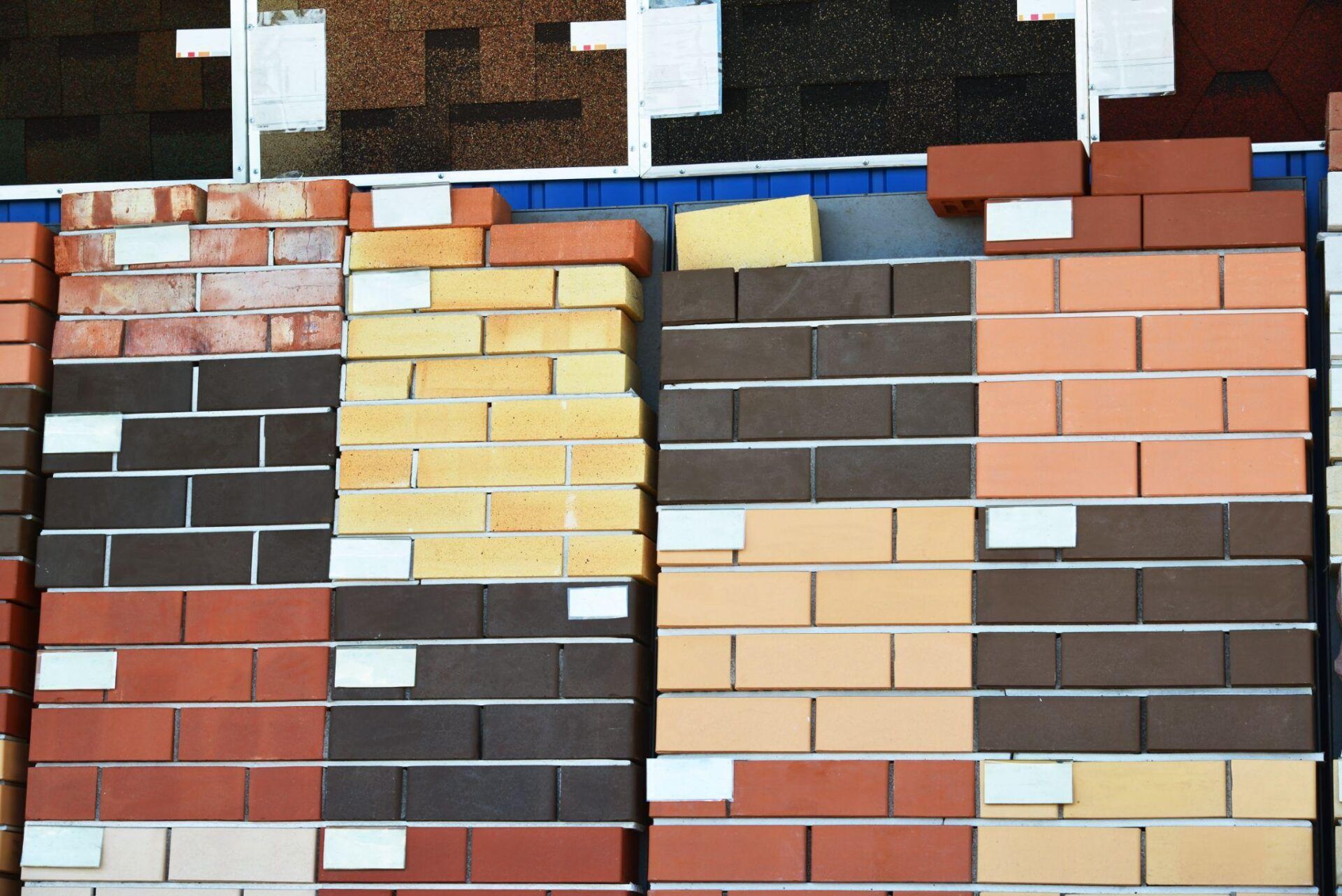 Various colored brick samples stacked for display at a building material store, showcasing diverse masonry options.