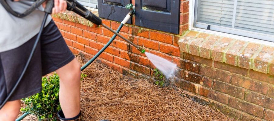 a man is using a water hose to clean the grass
