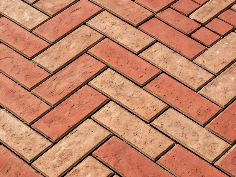 Red and brown herringbone brick pattern, ideal for durable paving and stylish outdoor flooring designs.