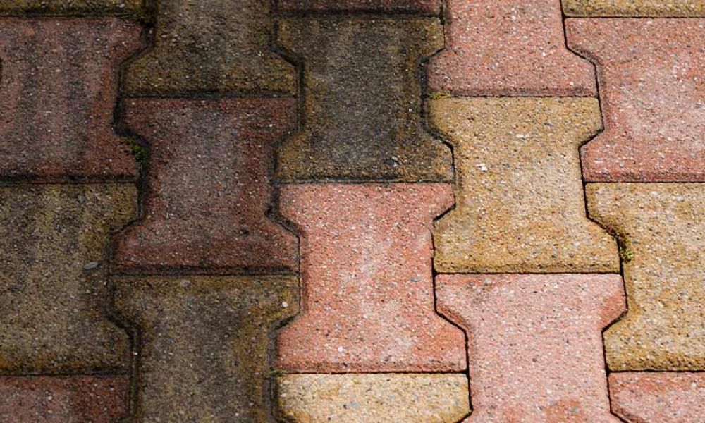 Interlocking brick pavement in red and beige hues with a worn texture, ideal for garden paths and outdoor spaces.