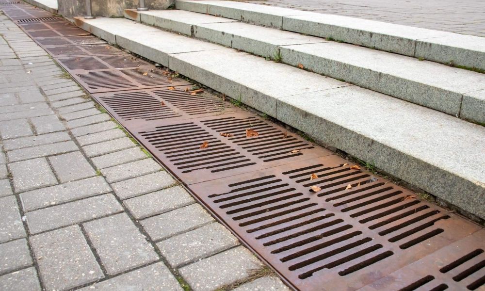 a manhole cover or flood vent sitting on the side of a street