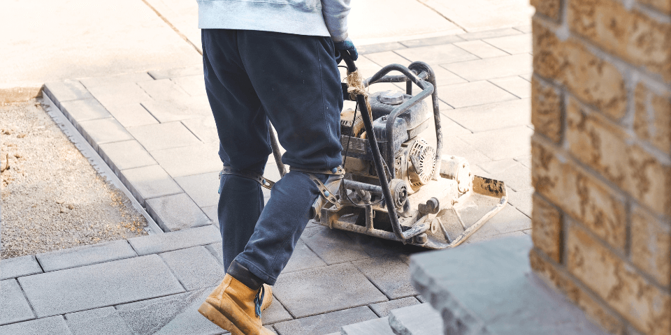 plate compactor being used on top of pavers for sand installation