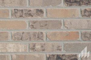 Rustic brick wall pattern with varying shades of brown and beige bricks, providing a textured, vintage look.