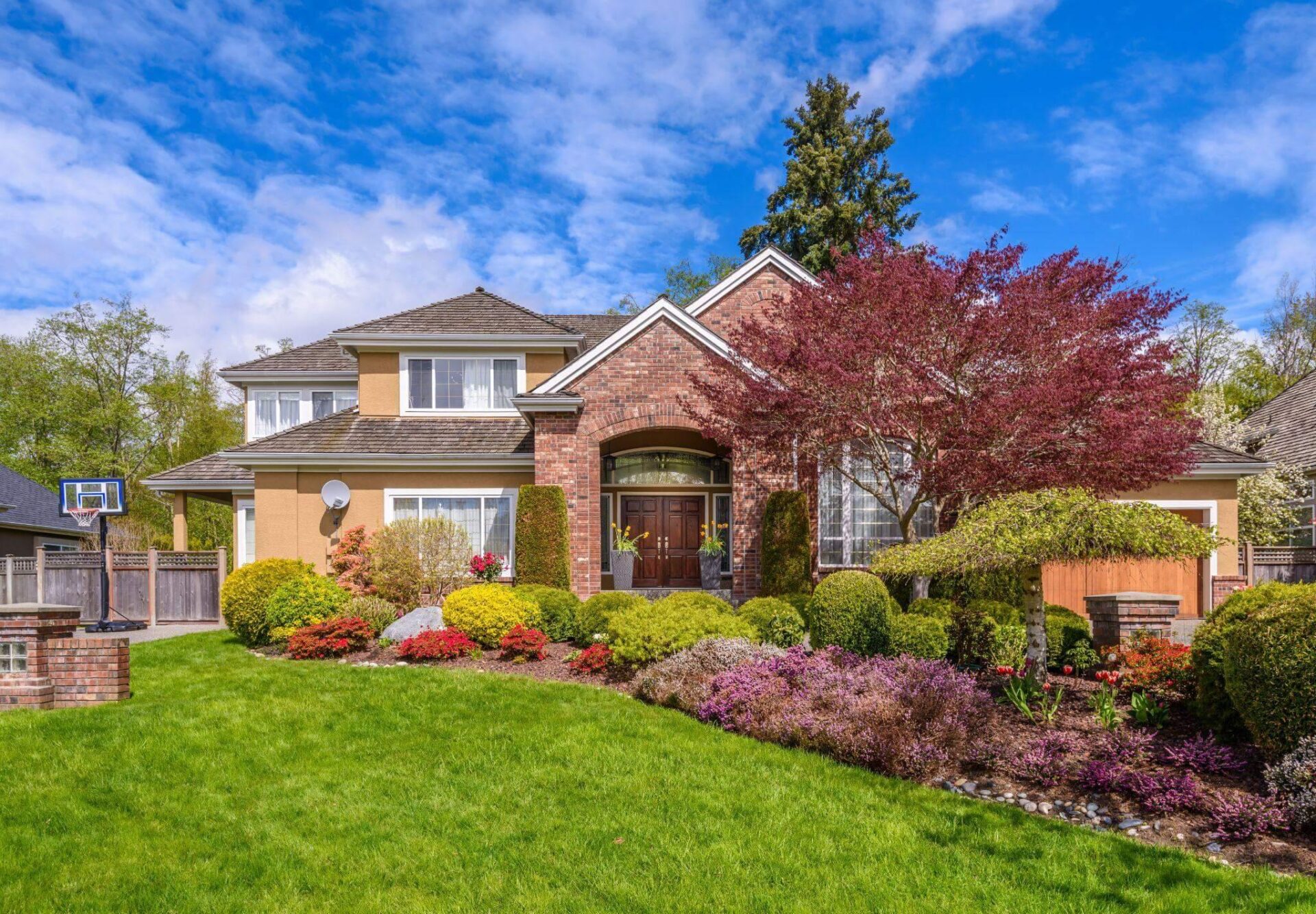 a house with a large front yard and landscaping, the house is made of bricks