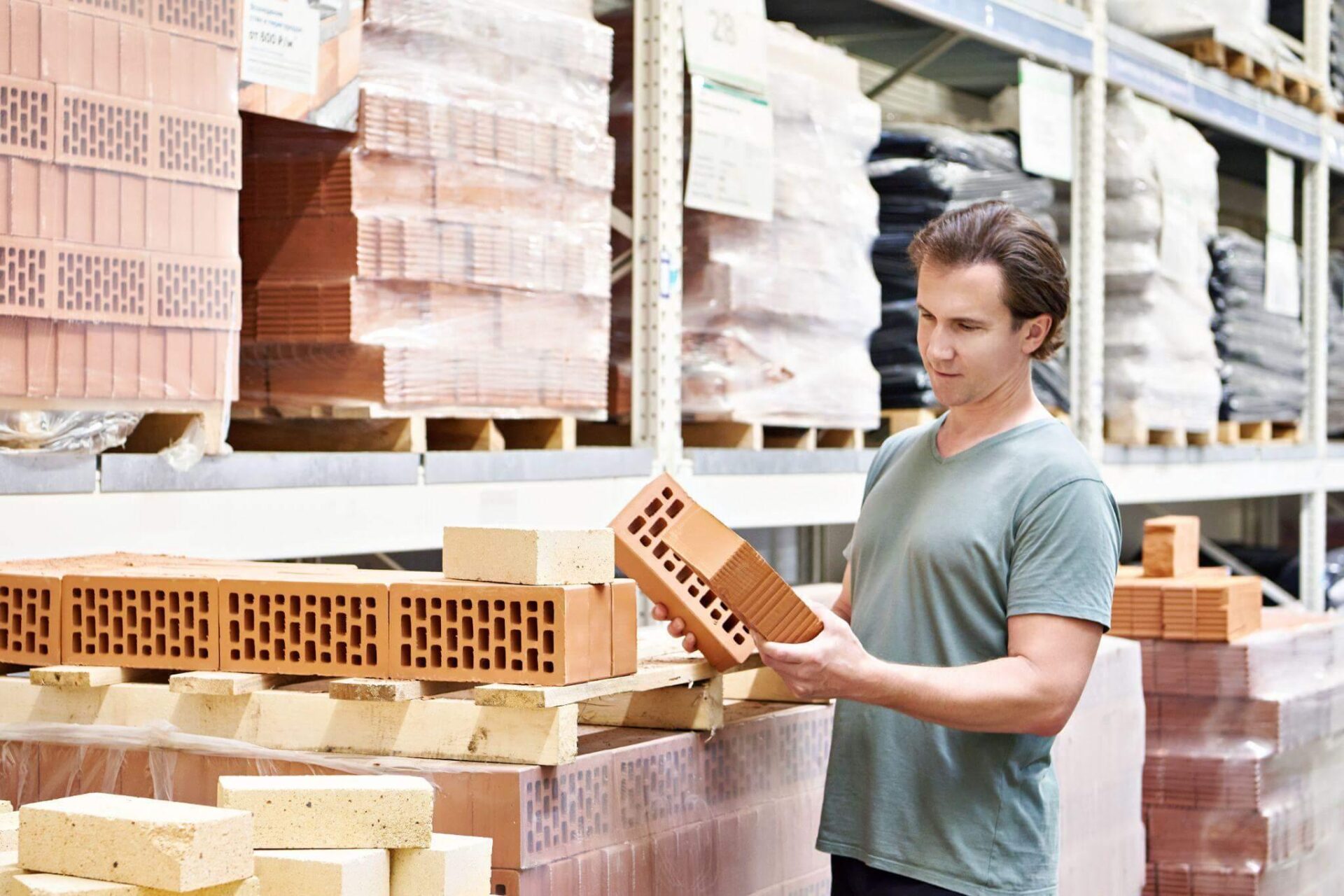a man holding a piece of wood in a warehouse