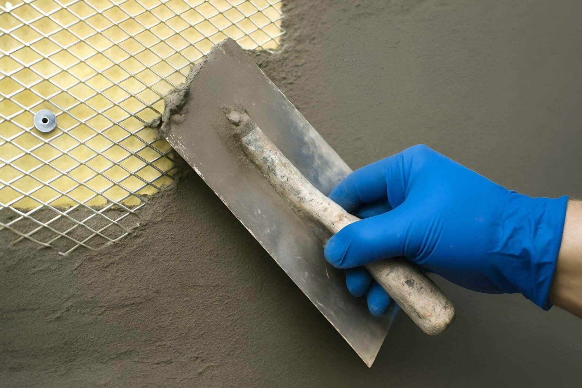 a person in blue gloves and blue rubber gloves is holding a large piece of metal