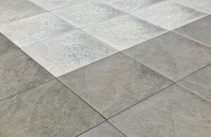 Close-up of a textured gray and white tile floor, showcasing square patterns and subtle shading variations.
