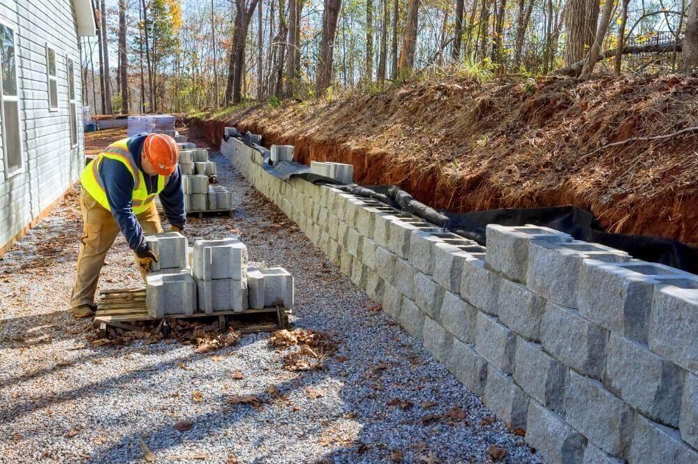 Man in yellow vest working on a retaining wall